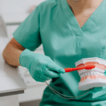 Hygienist with mouth model and toothbrush