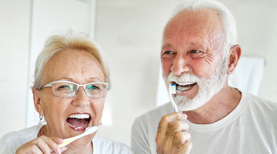 Elderly couple brushing teeth