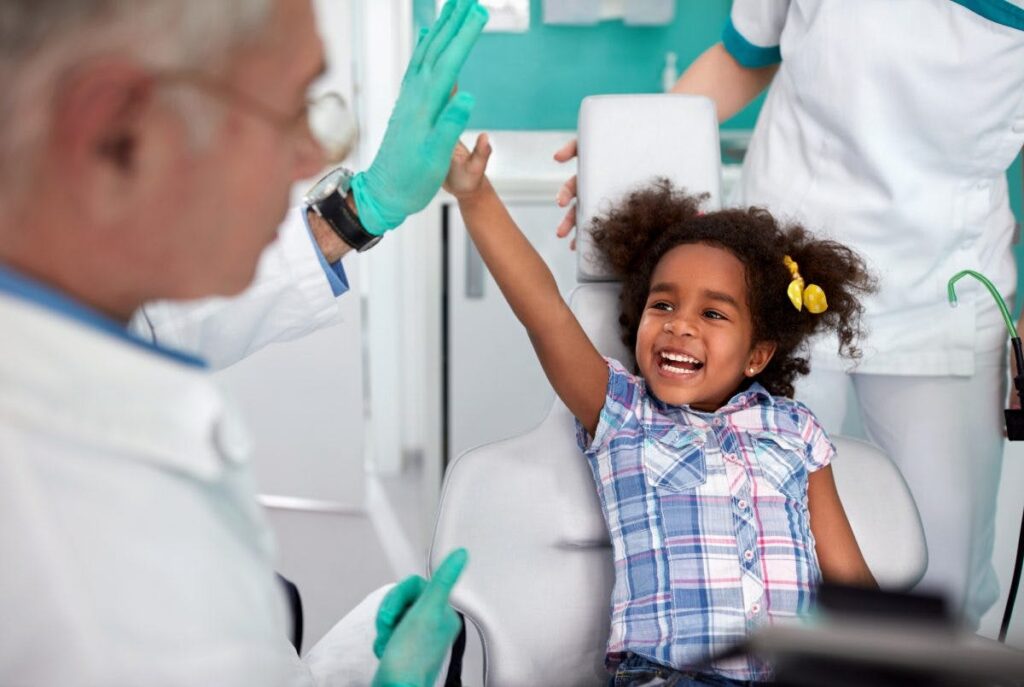 child high fiving dentist